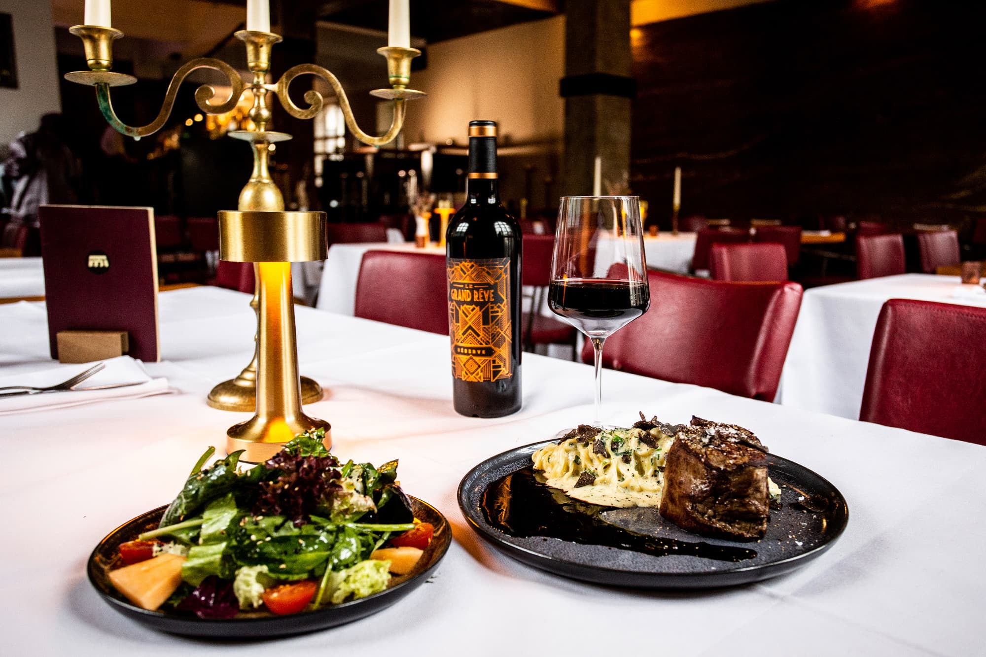 Gedeckte Tafel mit Catering im Saal der Eventlocation